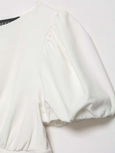 Close-up of white puff sleeves featuring delicate pleated texture and high-quality fabric