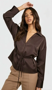 Detail einer braunen Satinbluse mit tiefem V-Ausschnitt, Kordelzug und Seidentextur