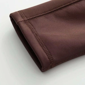 Detail of professional flatlock stitching on dark brown knit yoga athletic wear sleeve