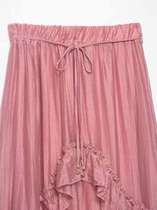 Detail of pink ruffled skirt showing elastic waist, drawstring, and metal charms