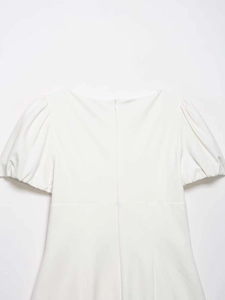 Detail view of a white puff sleeve dress featuring a discreet back zipper and smooth fabric