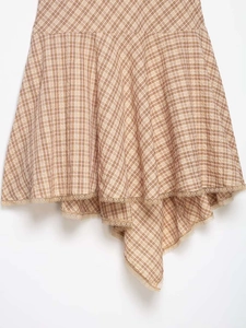 Détail d'une robe vintage à carreaux avec ourlet asymétrique et bordure en dentelle