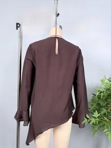 Detail view of coffee chiffon blouse featuring asymmetrical hem and ruffled sleeve cuffs