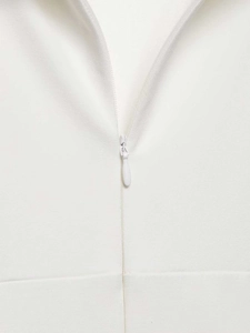 Detailed macro view of the invisible zipper closure on this white short sleeve dress