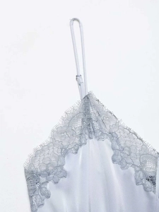 Detail of light blue satin camisole top featuring delicate lace trim and adjustable strap