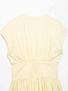 Detail of light yellow sleeveless dress showing pleated waistline and smooth fabric texture