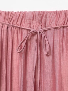 Macro detail of elastic waistband with pink drawstring bow on a ruffled skirt