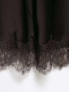 Gros plan détaillé sur la bordure en dentelle noire délicate d'un ourlet de jupe en satin