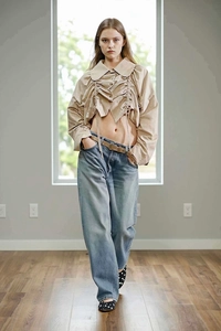 Detail of apricot drawstring jacket with oversized collar paired with wide-leg jeans