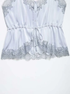 Detailed close-up of lace-trimmed satin V-neck camisole with adjustable drawstring waist