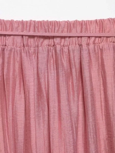 Detail of pink ruffled elastic waist with decorative thin belt and textured fabric