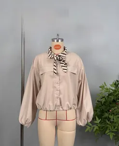 Detail of apricot blouse with zebra print tie-collar and puff sleeves for women