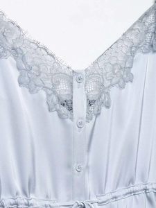 Close-up of V-neck eyelash lace trim and satin fabric with delicate buttons on the top
