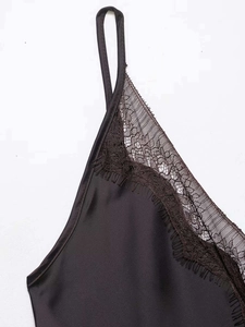 Detail of delicate eyelash lace trim on black satin camisole dress neckline
