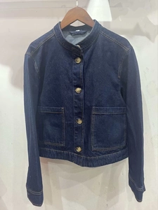 Detail van donkerblauw denim jack met opstaande kraag en grote opgestikte zakken