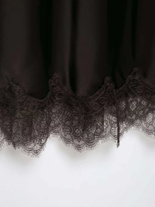 Vue détaillée de l'ourlet en satin noir avec dentelle cils délicate et texture soyeuse