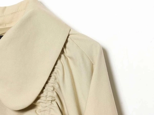Detail of apricot Peter Pan collar and gathered shoulder pleats on a twill jacket