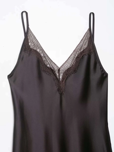 Detailed view of black satin slip dress featuring elegant lace trim and V-neckline