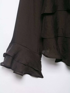 Detail shot of multi-layered ruffles on dark brown chiffon fabric with soft silky texture