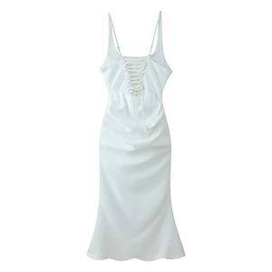 Detail of the white satin dress featuring back lace-up straps and elegant waist ruffles