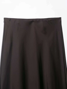 Détail de la taille d'une jupe en satin élégante avec coutures cachées et tissu sombre lisse