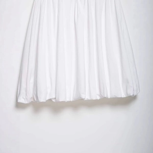 Chic white pleated midi skirt with stylish rivet accents and a unique balloon hem design