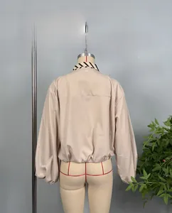 Detail of beige striped shirt featuring puff sleeves and contrast neckline trim