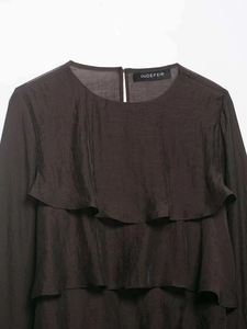 Detail of dark brown chiffon blouse featuring ruffled front layers and smooth texture