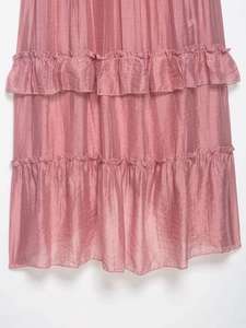 Close-up of pink tiered ruffle skirt showing vertical texture and silky fabric detail