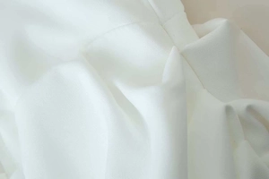 Close-up of white summer dress fabric showing high-quality twill texture and stitching