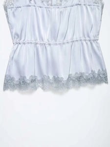 Detailed view of satin camisole with eyelash lace trim and ruched waist detail