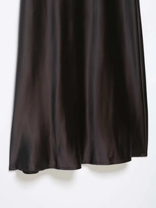 Detailed view of black satin lace dress hem featuring glossy fabric and smooth texture