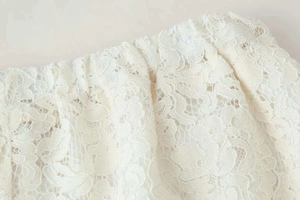 Detailed macro view of high-quality white floral lace fabric on these wide-leg pants