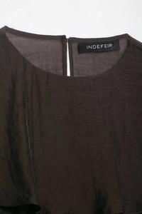 Macro view of sheer pleated chiffon fabric texture and round neck detail with back slit