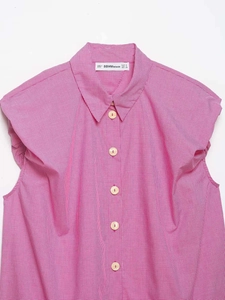 Detailed view of pink gingham sleeveless shirt with white buttons and collared neck