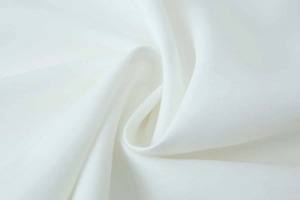 Close-up of white woven fabric texture showing smooth drape and plain weave details