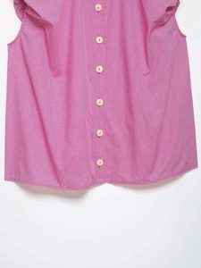 Detailed close-up of pink and white checkered sleeveless shirt with wooden buttons