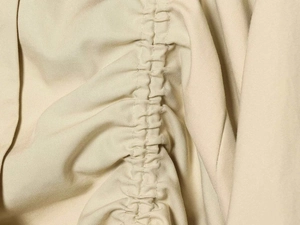Macro shot of apricot twill fabric texture with detailed ruched drawstring stitching