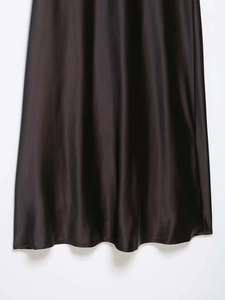Detail of elegant black satin dress hem showing high gloss texture and smooth drape