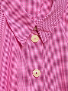 Detail shot of a pink and white gingham striped sleeveless shirt showing collar and buttons