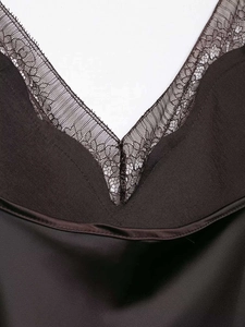 Detail shot of elegant V-neckline with black eyelash lace and smooth satin fabric finish