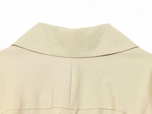 Detail of the elegant beige Peter Pan collar and fine twill fabric stitching on the jacket