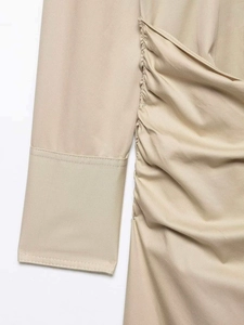 Détail de robe midi beige avec fronces latérales et texture en coton sergé