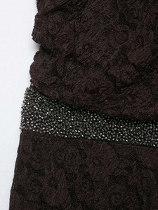 Détail de la robe en dentelle marron avec perles argentées et textures en maille