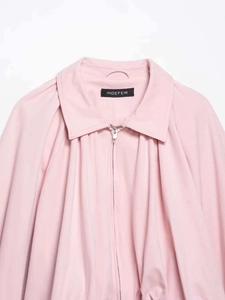 Detail of light pink bomber jacket featuring metal zipper and brand neck label