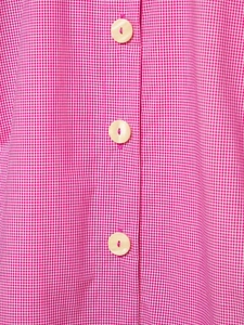 Detailed macro view of pink gingham fabric with white buttons on a sleeveless summer blouse