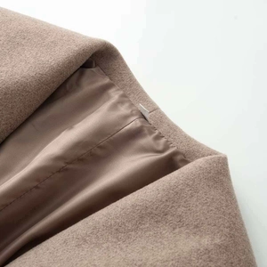 Close-up of wool texture and smooth lining on a warm camel lapel coat with fine stitching