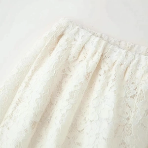 Elegant white lace wide leg pants with intricate floral patterns and pleated details