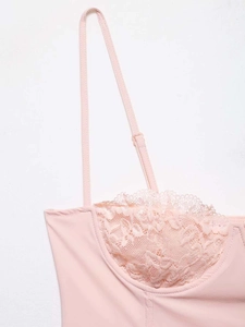 Detailed view of delicate floral lace stitching and adjustable strap on pink satin camisole