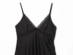 Detail shot of black satin nightdress featuring delicate lace trim and a deep V-neckline